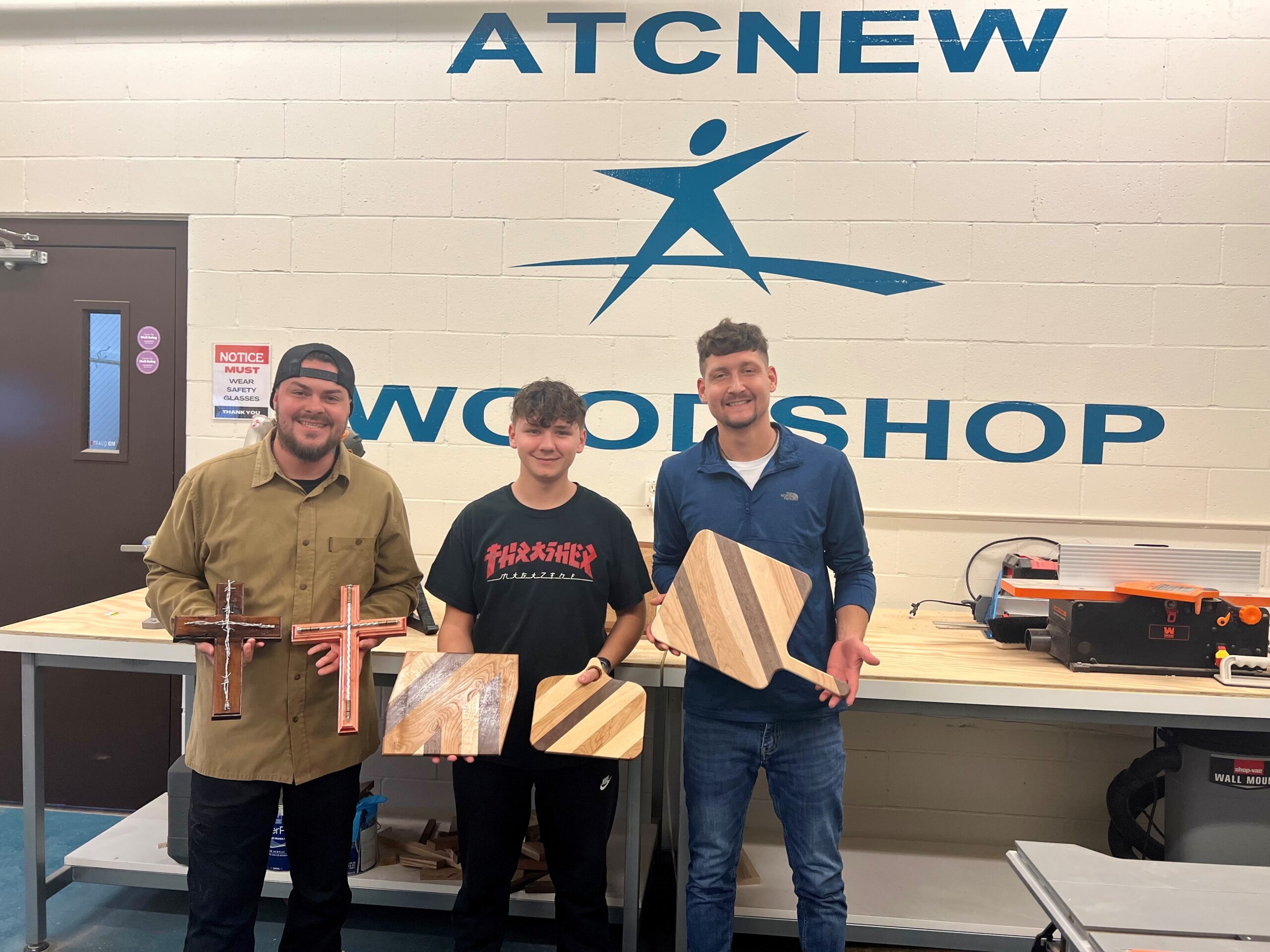 clients holding woodshop creations